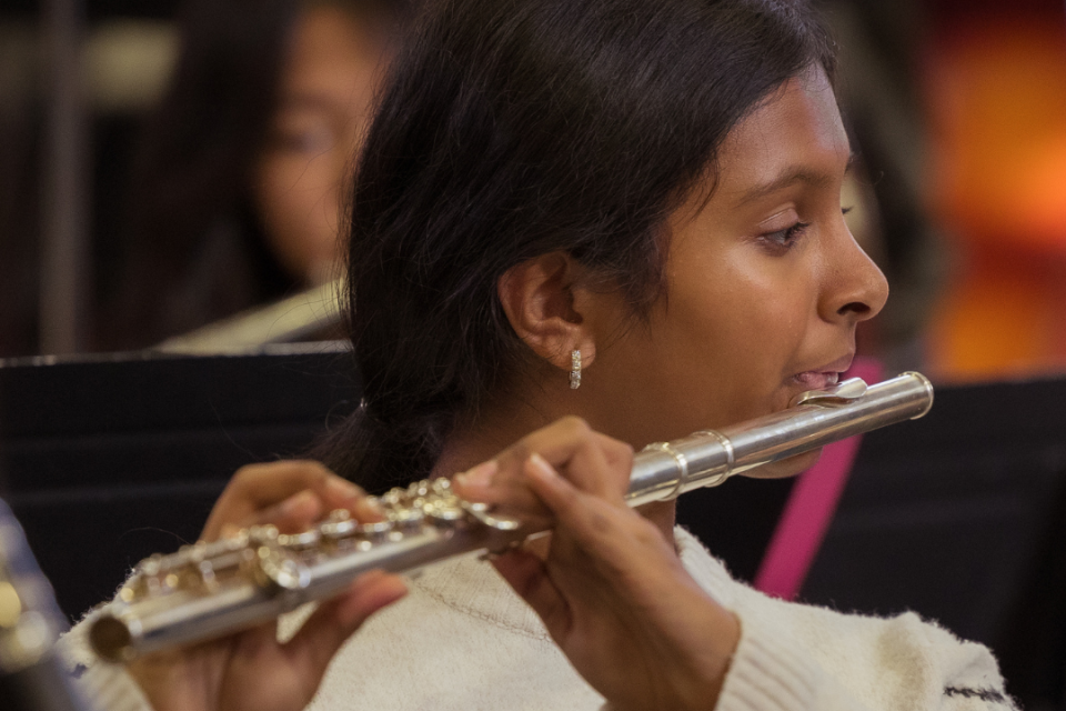 Middle school student playing flute in music class. 