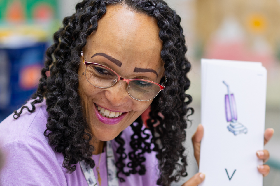 Teacher pointing to a card with the letter "v"
