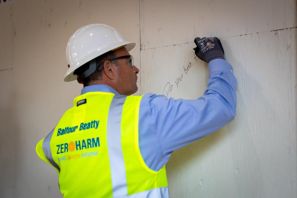 Superintendent Derk Garcia signing an interior wall at Winding Creek