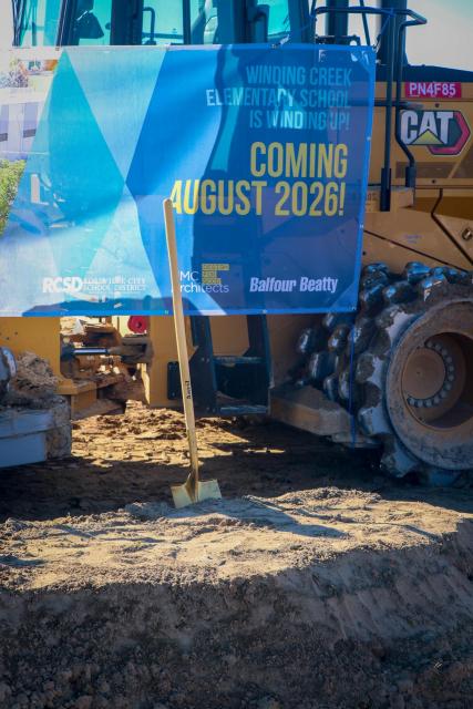 A shovel sticking out of a mound of dirt in front of a banner that says "Coming August 2026!"