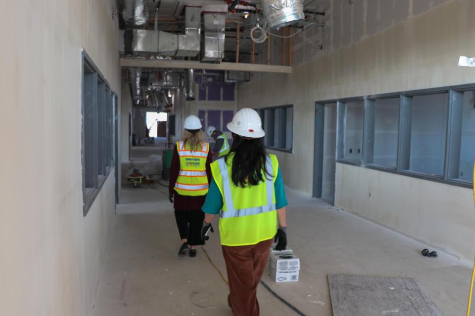 Two people walking down hallway under construction 