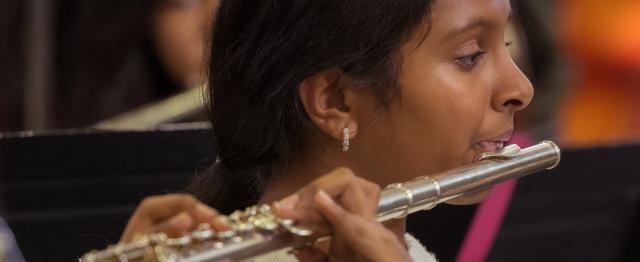 Middle school student playing flute in music class.